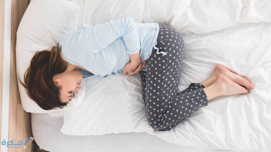 شرح خطوات علاج سبب انتفاخ البطن والامساك بالاعشاب 1 woman with stomach ache lying in bed 1296x728 1